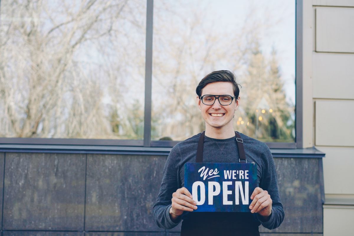 Small business owner standing in the doorway of their company