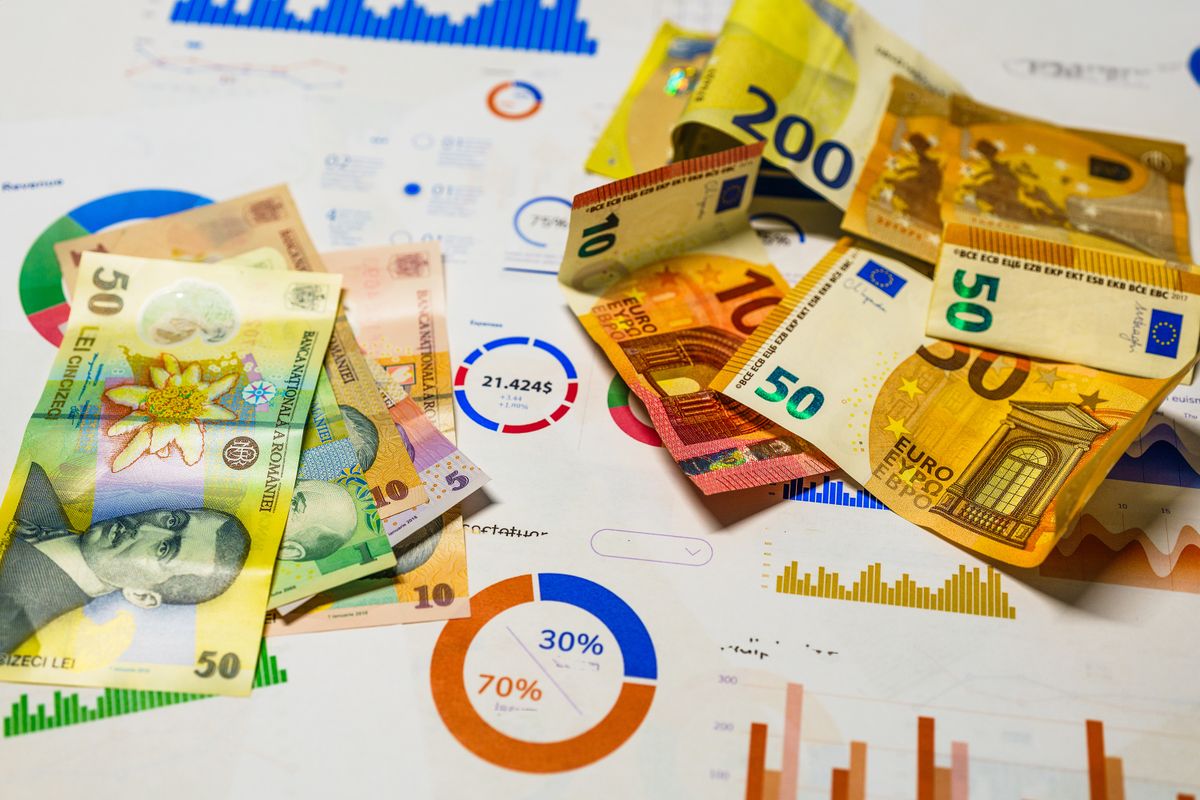 Banknotes resting on printed financial charts